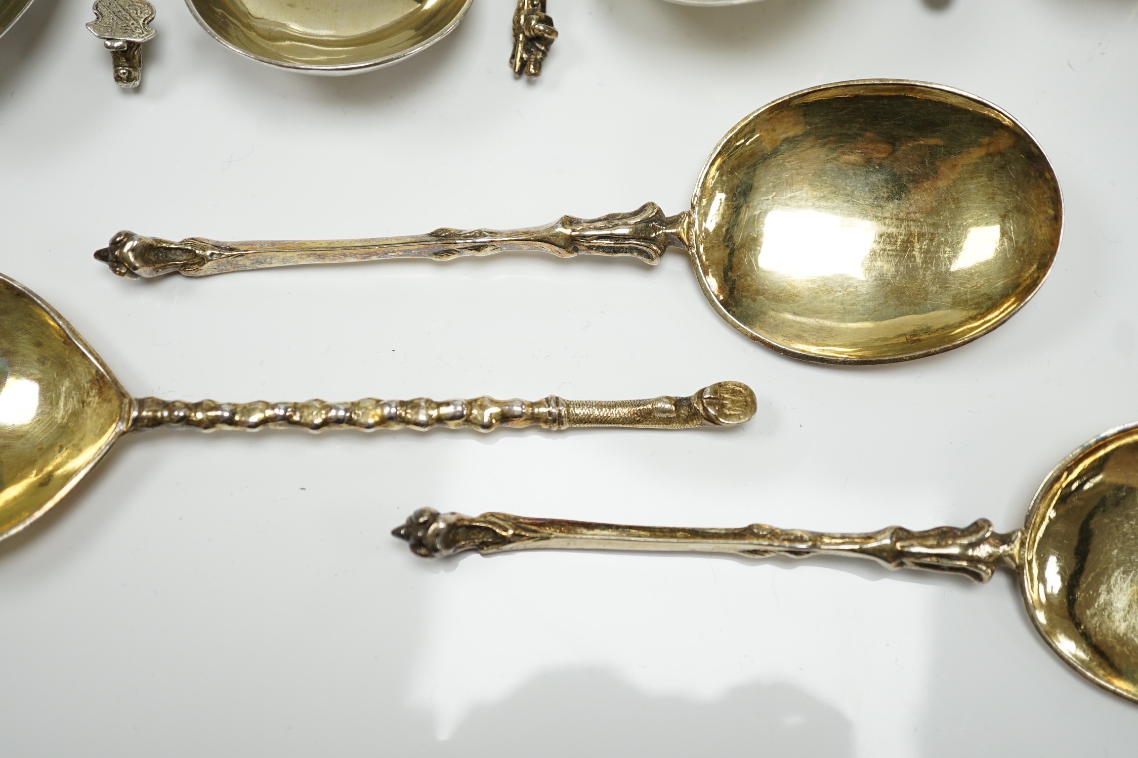 Twelve assorted 19th century and later Scandinavian or Dutch? gilt or parcel gilt white metal spoons, with differing stems including apostle, largest 18.8cm, 19.3oz.